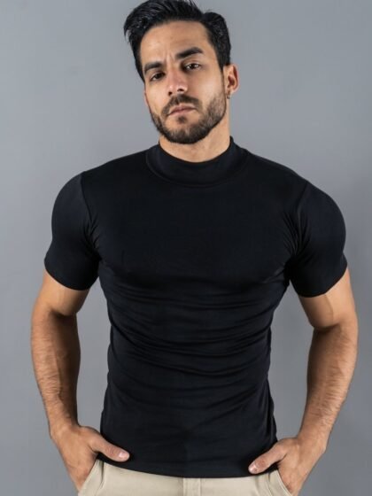 Hombre vistiendo polo negro Maniche Corte de Ezzeta, con estilo casual y clásico.