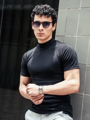 Hombre vistiendo polo negro Maniche Corte de Ezzeta, con estilo casual y clásico.