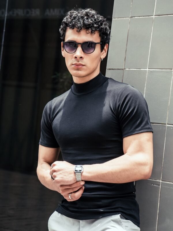 Hombre vistiendo polo negro Maniche Corte de Ezzeta, con estilo casual y clásico.