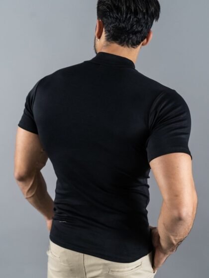 Hombre vistiendo polo negro Maniche Corte de Ezzeta, con estilo casual y clásico.