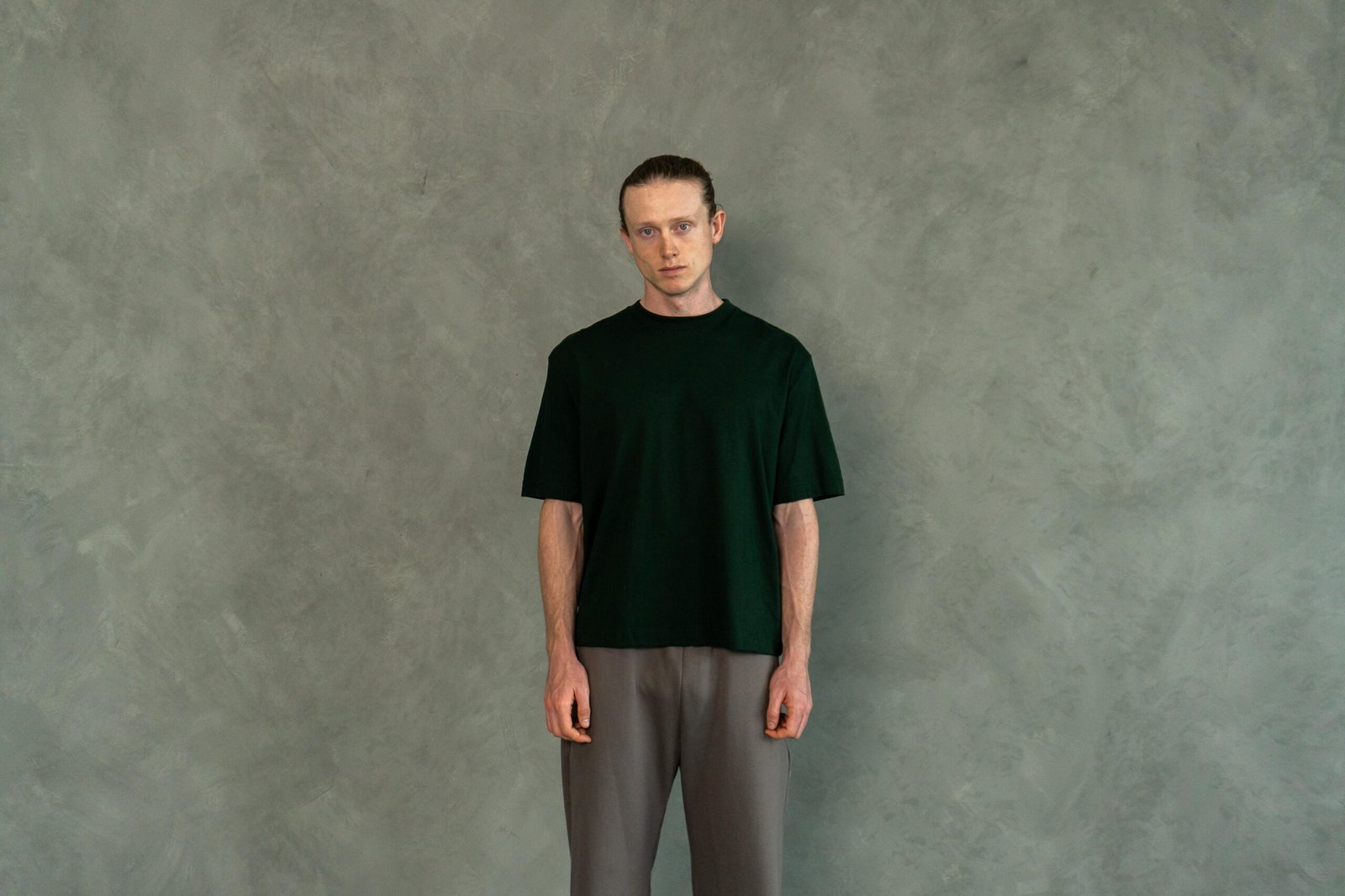 Hombre con estilo urbano vistiendo el polo verde boxy fit de Ezzeta Company. 