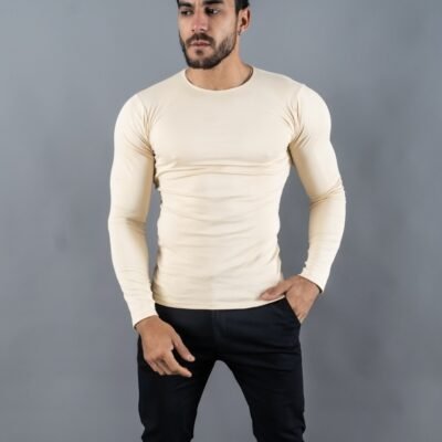 Hombre vistiendo polo beigeManiche Lunche Large de Ezzeta, con mangas largas y estilo casual.