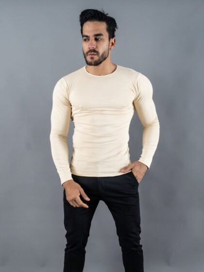 Hombre vistiendo polo beigeManiche Lunche Large de Ezzeta, con mangas largas y estilo casual.