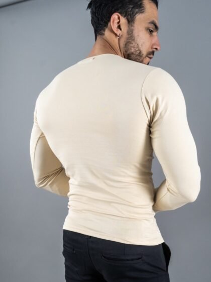 Hombre vistiendo polo beigeManiche Lunche Large de Ezzeta, con mangas largas y estilo casual.