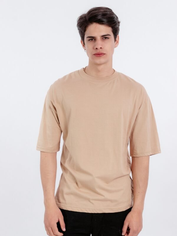 Hombre vistiendo polo beige oversize de Ezzeta, mostrando el corte relajado y el color intenso.