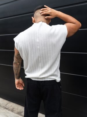 Hombre vistiendo polo blanco Manica Zero de Ezzeta, con diseño sin mangas y estilo urbano.