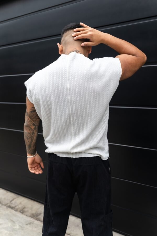 Hombre vistiendo polo blanco Manica Zero de Ezzeta, con diseño sin mangas y estilo urbano.