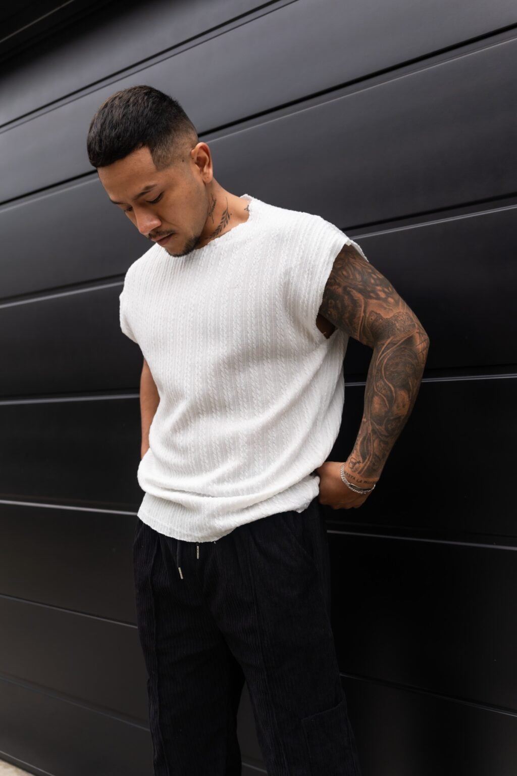 Hombre vistiendo polo blanco Manica Zero de Ezzeta, con diseño sin mangas y estilo urbano.