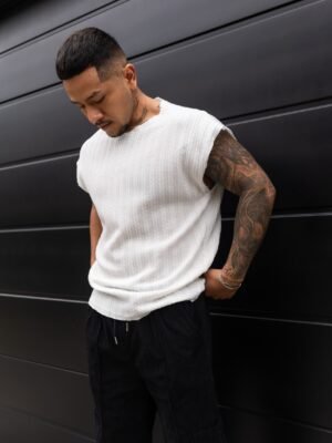 Hombre vistiendo polo blanco Manica Zero de Ezzeta, con diseño sin mangas y estilo urbano.
