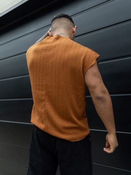 Hombre vistiendo polo camell Manica Zero de Ezzeta, con diseño sin mangas y estilo urbano.