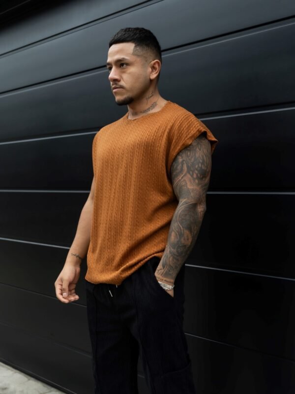 Hombre vistiendo polo camell Manica Zero de Ezzeta, con diseño sin mangas y estilo urbano.