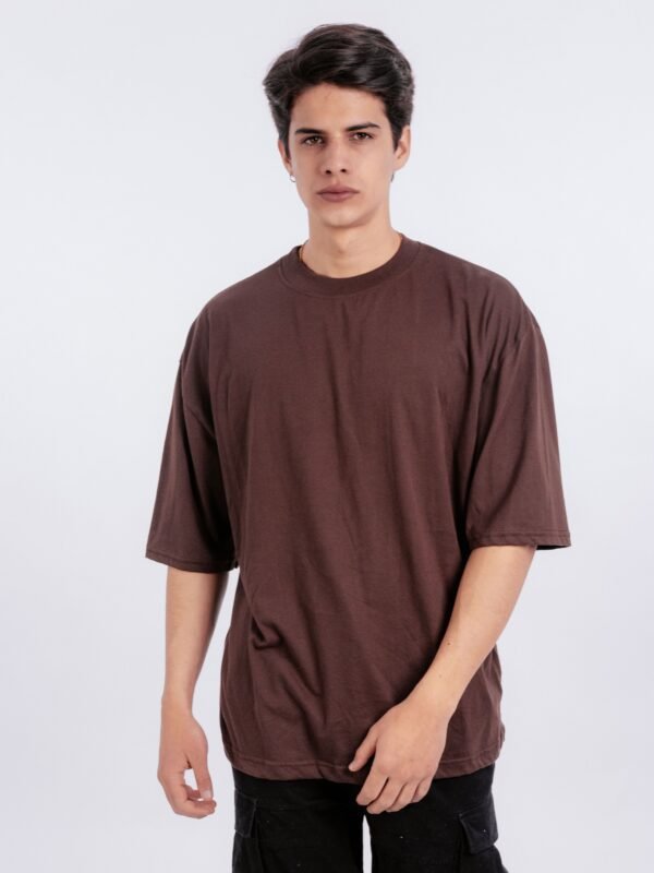 Hombre vistiendo polo marron oversize de Ezzeta, mostrando el corte relajado y el color intenso.
