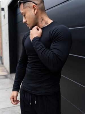 Hombre vistiendo polo negro Maniche Lunche Large de Ezzeta, con mangas largas y estilo casual.