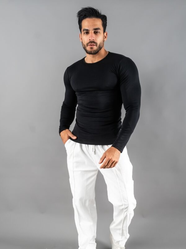 Hombre vistiendo polo negro Maniche Lunche Large de Ezzeta, con mangas largas y estilo casual.