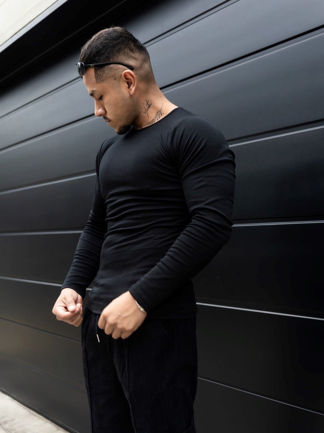 Hombre vistiendo polo negro Maniche Lunche Large de Ezzeta, con mangas largas y estilo casual.